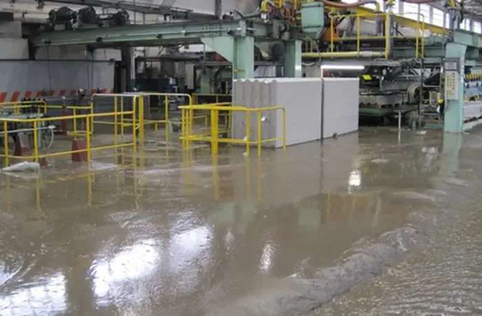 Standing water across the floor of an industrial plant