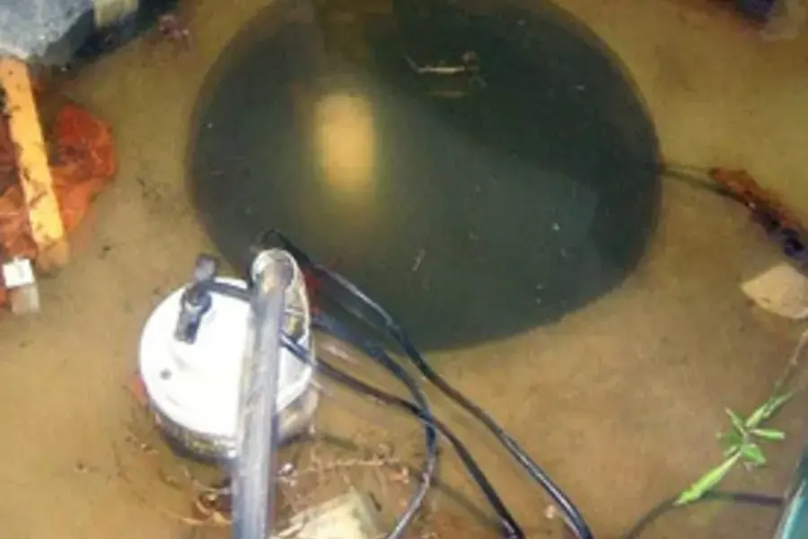 Water pooled over a flooded sump pit with the pump submerged